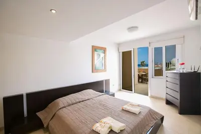 a bedroom with a large bed with two towels at Apt Lasonos Asimi - Luxury 3 Bedroom Protaras Apartment - Communal Pool in Protaras