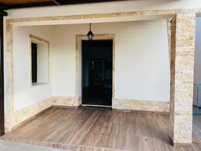 a room with a white wall and a wooden floor at Lovely house not far from the beach, near Protaras in Dherinia