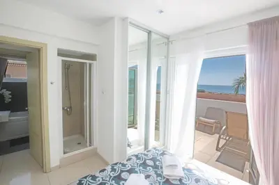 a bedroom with a bed and a balcony with the ocean at Sunrise Villa 12 in Ayia Napa