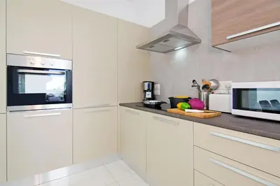 a kitchen with white cabinets and a microwave at Villa Luna in Protaras