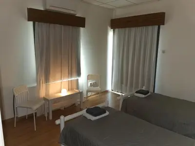 a bedroom with two beds and a desk and a table at Kakopetria Heights in Kakopetria
