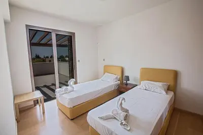 two beds in a room with a balcony at Villa Petreris Dyo - Lovely 3 Bedroom Central Ayia Napa Villa With Pool in Ayia Napa