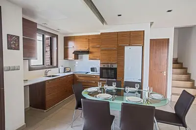 a kitchen with a glass table and chairs in a kitchen at Villa Petreris Dyo - Lovely 3 Bedroom Central Ayia Napa Villa With Pool in Ayia Napa