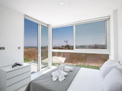 a bedroom with a bed and a large window at Villa Manta Agrotikos - Stunning 3 Bedroom Protaras Villa With Pool in Protaras