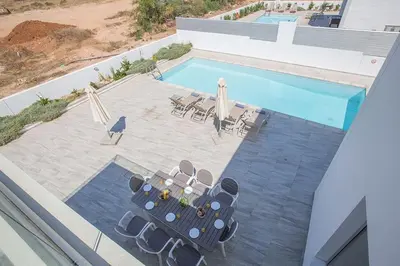 an overhead view of a swimming pool with chairs and umbrellas at Villa Ochosto Eos - Luxury 5 Bedroom Protaras Villa With Private Pool - Close in Protaras
