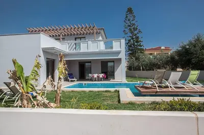 a villa with a swimming pool and a house at Villa Petreris Enas - Stunning 3 Bedroom Central Ayia Napa Villa With Pool in Ayia Napa