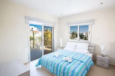 a white bedroom with a bed and a large window at Villa Dafnis Platina - Lovely 4 Bedroom Protaras Villa With Private Pool in Protaras