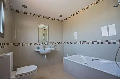 a bathroom with a tub and a toilet and a sink at Villa Dafnis Platina - Lovely 4 Bedroom Protaras Villa With Private Pool in Protaras