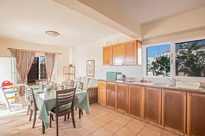 a kitchen with a table and a dining room at Villa Magusta - Modern 4 Bedroom Ayia Thekla Villa With Pool in Ayia Napa