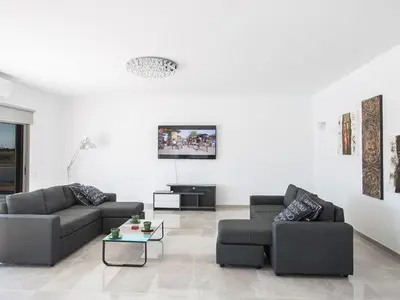 a living room with two couches and a tv at Villa Ioanni Chrysos - Luxury And New 6 Bedroom Protaras Villa in Protaras