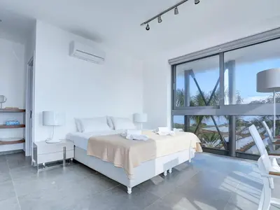a white bedroom with two beds and a large window at Villa Limni Dyo - Luxurious Contemporary 3 Bedroom Villa With Sea Views And Hot in Paralimni