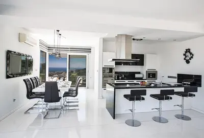 a white kitchen with black chairs and a table at Villa Saranta Gold - Exquisite 3 Bedroom Protaras Villa With Private Pool in Protaras