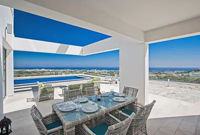 a dining room with a view of the ocean at Villa Saranta Gold - Exquisite 3 Bedroom Protaras Villa With Private Pool in Protaras