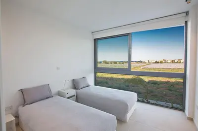 a bedroom with two beds and a large window at Villa Limni Enas - Luxury And Contemporary 3 Bedroom Kapparis Villa With Sea View in Paralimni