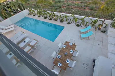 an overhead view of a swimming pool with chairs and a table at Villa Limni Enas - Luxury And Contemporary 3 Bedroom Kapparis Villa With Sea View in Paralimni