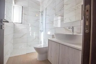a white bathroom with a toilet and a sink at Villa Olive Titan, Brand New,Exquisite 5Bdr Protaras Villa With Pool in Protaras