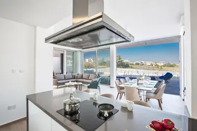a kitchen and living room with a view of the ocean at Villa Olive Titan, Brand New,Exquisite 5Bdr Protaras Villa With Pool in Protaras