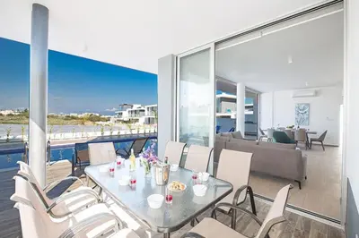 a dining room with a table and chairs on a balcony at Villa Olive Titan, Brand New,Exquisite 5Bdr Protaras Villa With Pool in Protaras