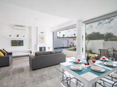 a living room with a table and a couch at Villa Olive Bronze, Luxurious 2Bdr With Pool, Close To Protaras Strip And Beach in Protaras