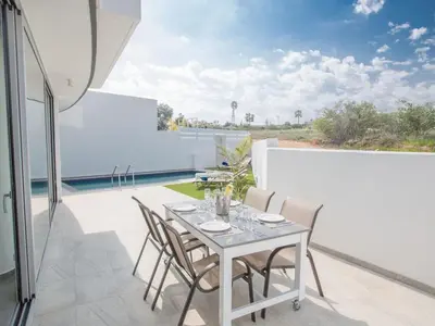 a dining room with a table and chairs on a patio at Villa Olive Bronze, Luxurious 2Bdr With Pool, Close To Protaras Strip And Beach in Protaras
