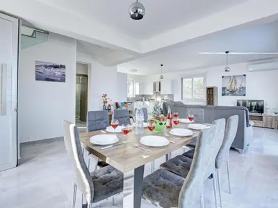 a dining room with a wooden table and chairs at Villa Kono Provoles - Luxury 4 Bedroom Protaras Villa With Stunning Panoramic in Protaras