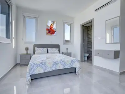 a white bedroom with a large bed and windows at Villa Kono Provoles - Luxury 4 Bedroom Protaras Villa With Stunning Panoramic in Protaras