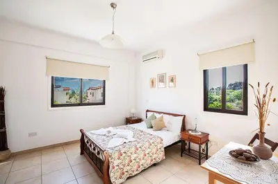 a bedroom with a bed and two windows at Villa Kanthos - Beautiful 4 Bedroom Protaras Villa With Pool in Protaras