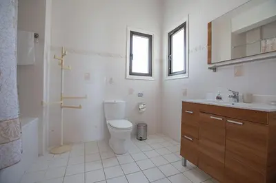 a white bathroom with a toilet and a sink at Villa Kanthos - Beautiful 4 Bedroom Protaras Villa With Pool in Protaras