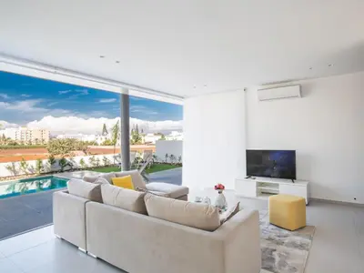 a living room with a couch and a large window at Villa Panemorfi - Luxury Brand New 3 Bedroom Protaras Villa With Private Pool in Protaras