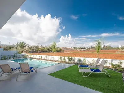 a patio with chairs and a swimming pool at Villa Panemorfi - Luxury Brand New 3 Bedroom Protaras Villa With Private Pool in Protaras