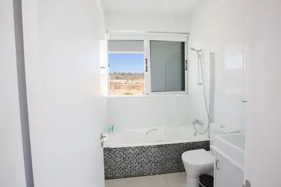 a white bathroom with a tub and a toilet at Villa Ochosto Selene - Stunning 5 Bedroom Protaras Villa With Private Pool in Protaras