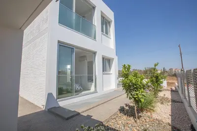 a white house with large windows and a fence at Villa Ochosto Selene - Stunning 5 Bedroom Protaras Villa With Private Pool in Protaras