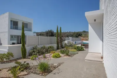 a white house with a courtyard with plants at Villa Ochosto Selene - Stunning 5 Bedroom Protaras Villa With Private Pool in Protaras