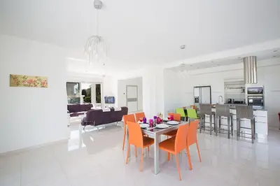 a dining room and living room with a table and chairs at Villa Protara Chrysos - Beautiful 5 Bedroom Protaras Villa - Walking Distance in Protaras