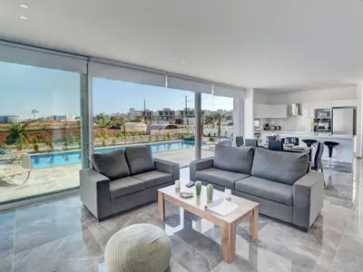 a living room with two couches and a table at Villa Manta Chrysos - Brand New Luxury 3 Bedroom Protaras Villa in Protaras