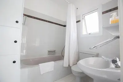 a white bathroom with a toilet and a sink at Villa Kavo Sunshine - Beautiful 3 Bedroom Protaras Villa With Private Pool in Protaras