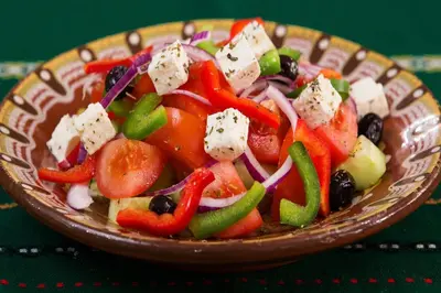 a bowl of salad with vegetables and cheese on a table at Villa Kono Sunshine - Luxury 4 Bedroom Cape Greco - Villa Close To Beach in Protaras