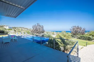 a house with a balcony with a swimming pool at Villa Kono Sunshine - Luxury 4 Bedroom Cape Greco - Villa Close To Beach in Protaras