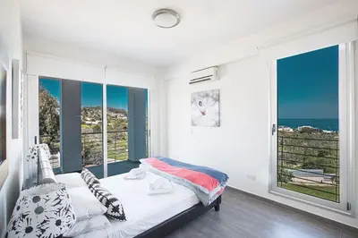 a bedroom with a bed with a view of the ocean at Villa Kono Sunshine - Luxury 4 Bedroom Cape Greco - Villa Close To Beach in Protaras