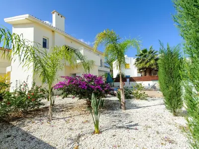 a house with palm trees in front of it at Villa Dafnis Helios - Lovely 3 Bedroom Central Protaras Villa With Pool in Protaras