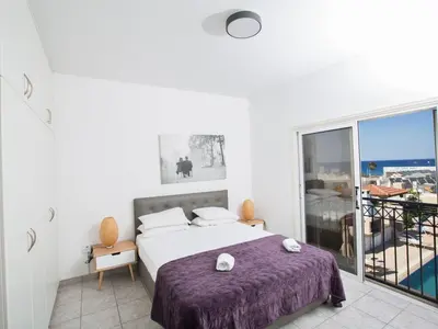 a white bedroom with a bed and a balcony at Villa Lefko Sunshine - Lovely 4 Bedroom Protaras Villa With Pool in Protaras