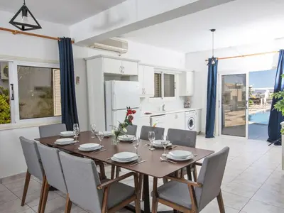 a dining room with a wooden table and chairs at Villa Lefko Sunshine - Lovely 4 Bedroom Protaras Villa With Pool in Protaras
