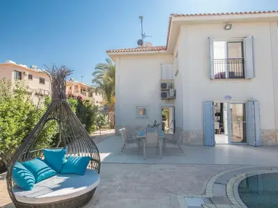 a patio with a hammock next to a house at Villa Lefko Sunshine - Lovely 4 Bedroom Protaras Villa With Pool in Protaras