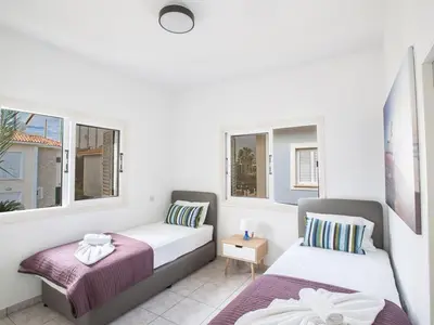 two beds in a room with two windows at Villa Lefko Sunshine - Lovely 4 Bedroom Protaras Villa With Pool in Protaras