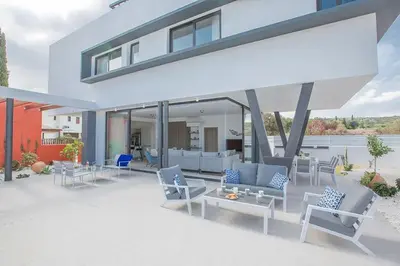 a house with a patio with blue and white furniture at Villa Apomono - New Luxury 3 Bedroom Protaras Villa With Pool in Protaras
