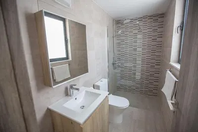 a bathroom with a sink and a toilet and a window at Villa Apomono - New Luxury 3 Bedroom Protaras Villa With Pool in Protaras