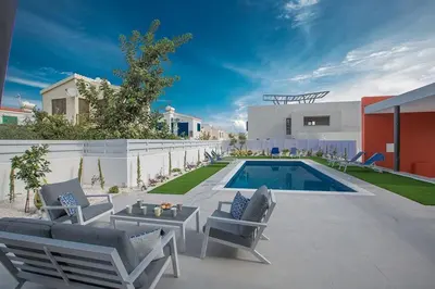 a backyard with a pool and chairs and a house at Villa Apomono - New Luxury 3 Bedroom Protaras Villa With Pool in Protaras