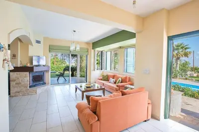 a living room with orange furniture and a fireplace at Villa Matronas Titan - Stunning 5 Bedroom Protaras Villa With Private Pool in Paralimni