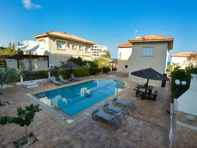 a swimming pool in front of a house at Villa Oforo Selene - Stunning 4 Bedroom Villa - By Fig Tree Bay Beach - Sea View in Protaras