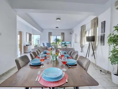 a dining room with a wooden table and chairs at Villa Oforo Selene - Stunning 4 Bedroom Villa - By Fig Tree Bay Beach - Sea View in Protaras